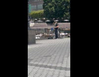 Man plays flute beside yachts in harbor