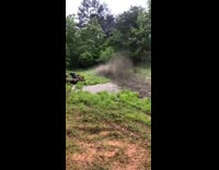 Guy rides red atv through mud water