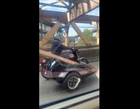 Man drives sidecar with long wood planks