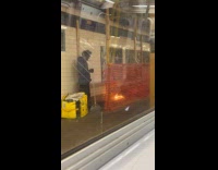 Man with broom beside fire at subway