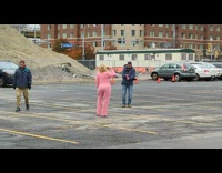 Woman in pink outfit drinks on the parking lot