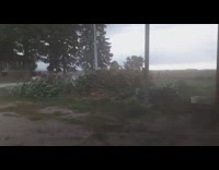 Heavy winds outside brown house stacked tires