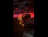 White car flipped sideways on road night