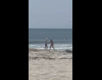 Man wears seagull head with woman at beach