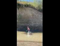 Guy jumps shallow mud water canadian flag 