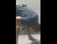 Guy playing trumpet with head between legs