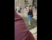Woman in white outfit raises hand inside the cathedral