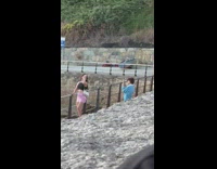 Woman in black crop top poses beside the railings
