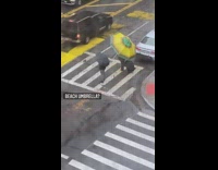 Person uses large green and yellow umbrella 