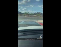 Small rain puddle in front of guy in car blue skies