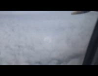 Rainbow ring around plane shadow on clouds