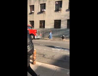 Two influencers take pictures opposite side of street