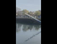 Half sunken boat in harbour near wood dock 