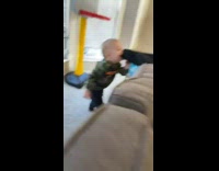 Little boy biting guys toe on couch while he plays with baby 