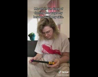Girl nintendo DS tucks shirt under breast