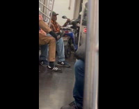 Man holds motorcycle inside the subway train