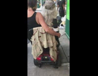 two people sharing motorized scooter in street