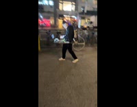 DJ plays music while walking on street