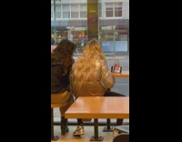 Two women records selfie video inside restaurant