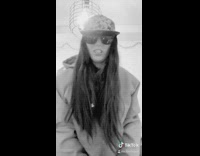 Girl lip syncs with grillz sunglasses hat