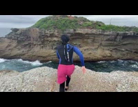 Guy wearing wetsuit and shorts does backflip 