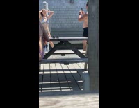 White bikini girl poses grey outdoor shower 