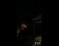 Guy holds traffic cone with firework that explodes
