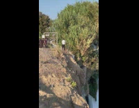 Man in formal attire on top and edge of the waterfalls 