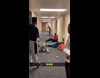 Guy throws ball at friend holding broom