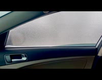 Woman push ice sheet formed on car window