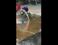 Purple hat lady squats park playground sprinklers 