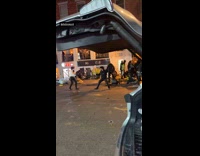 Two men sword fight side of street