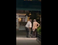 Doorman and elderly woman watch tribute lights