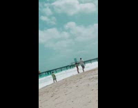 Man Green Shirt Pretends on phone beach