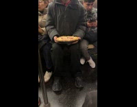 Cat holds cherry pie while riding subway