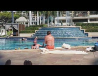 Woman in blue bikini dances in front of the fountain