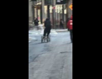 Guy rides platform cart down street