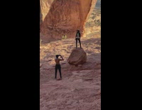 Woman Stands on Large Rock for Photo in Canyon
