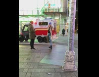 Girl long brown jacket dance street ambulance