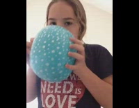 Blonde girl blue balloon sucks in helium falls backwards