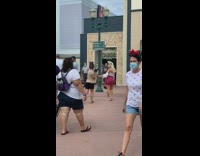 Woman red polka dots shorts hold hands Disneyland