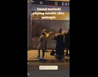 Mariachi band playing music on sidewalk at midnight