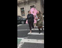 Woman in giant Kate Spade bag holds mini purple purse