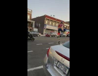 Guy rides white unicycle down street helmet