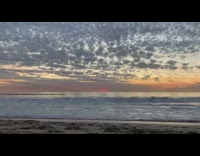 Filming beach waves sunset man jump shot 