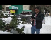Guy drinks from flask eats snow tree