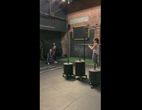 Woman records guy swinging kettlebell at gym