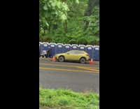 A long row of public portapotty urinals on the sidewalk 
