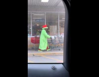 Man wears robe and hat push cart