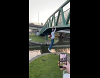 Guy hanging on edge of bridge falls in water